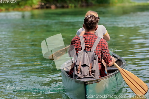 Image of friends are canoeing in a wild river