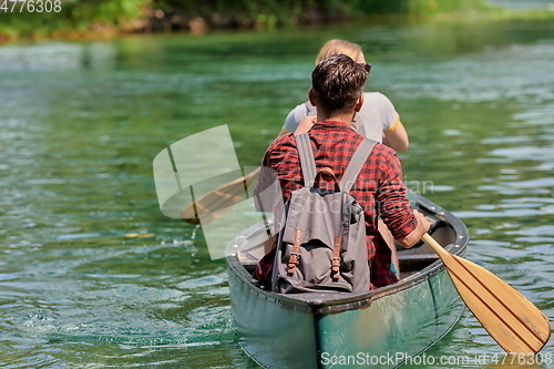 Image of friends are canoeing in a wild river