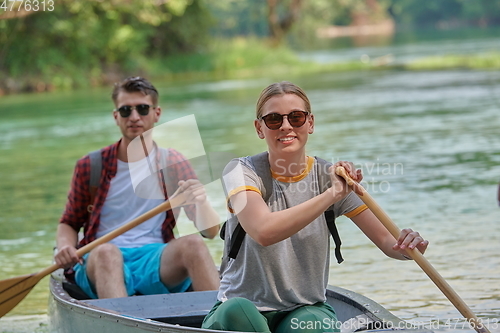 Image of friends are canoeing in a wild river