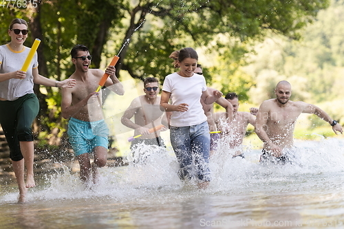 Image of group of happy friends having fun on river