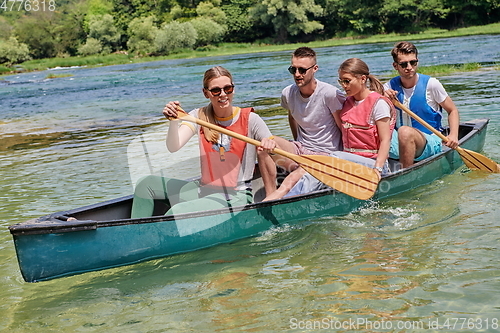 Image of Group adventurous explorer friends are canoeing in a wild river