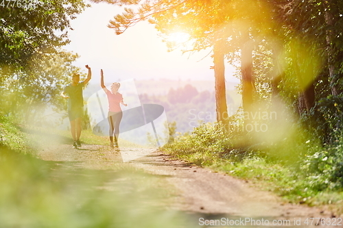 Image of couple enjoying in a healthy lifestyle while jogging on a country road