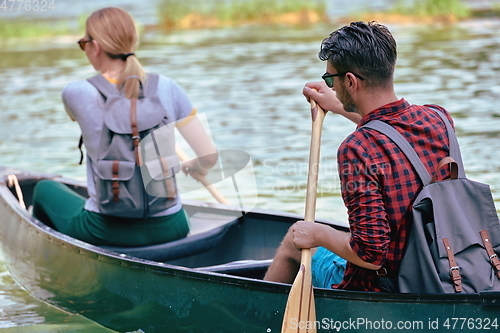 Image of friends are canoeing in a wild river