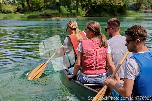 Image of Group adventurous explorer friends are canoeing in a wild river