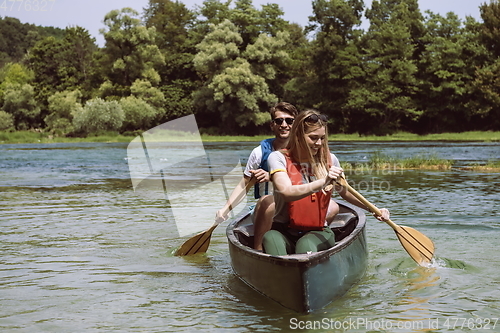 Image of friends are canoeing in a wild river