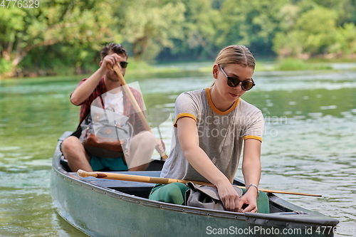 Image of friends are canoeing in a wild river