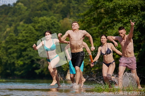 Image of group of happy friends having fun on river