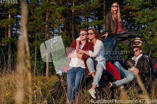 Image of group young happy people enjoying beautiful sunny day while driving a off road buggy car