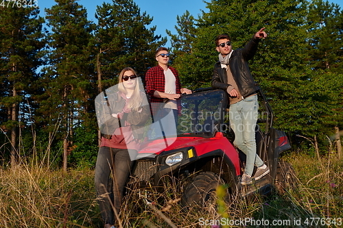 Image of group young happy people enjoying beautiful sunny day while driving a off road buggy car