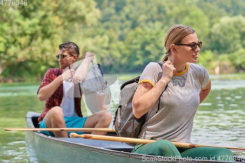 Image of friends are canoeing in a wild river