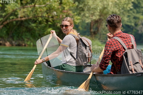 Image of friends are canoeing in a wild river