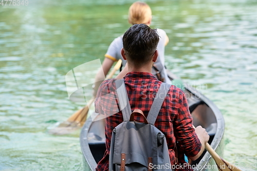 Image of friends are canoeing in a wild river