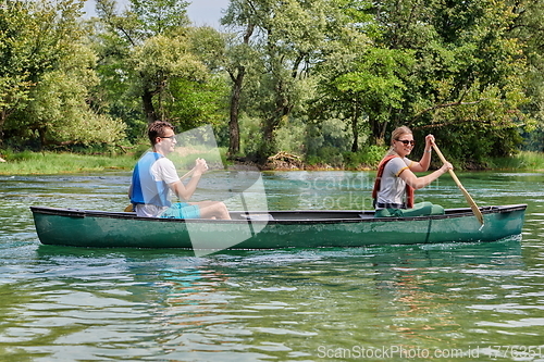 Image of friends are canoeing in a wild river