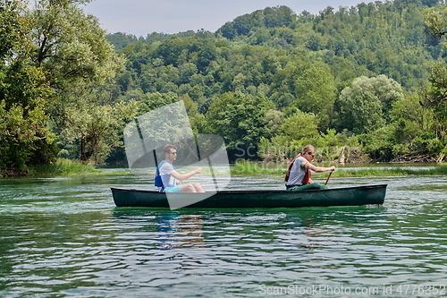Image of friends are canoeing in a wild river
