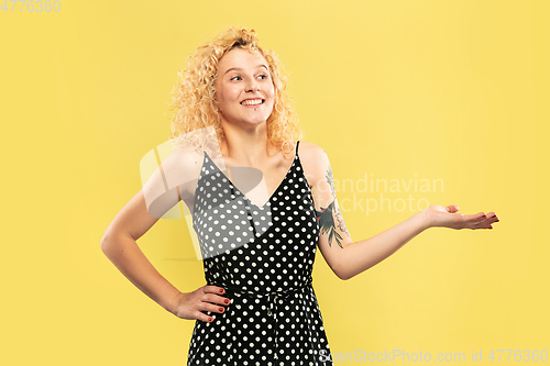 Image of Caucasian young woman\'s half-length portrait on yellow background