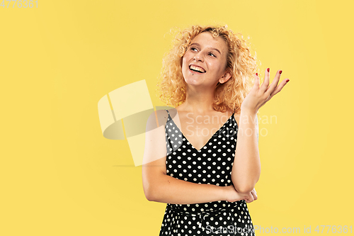 Image of Caucasian young woman\'s half-length portrait on yellow background