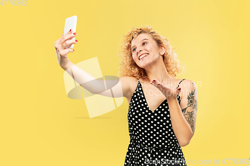 Image of Caucasian young woman\'s half-length portrait on yellow background