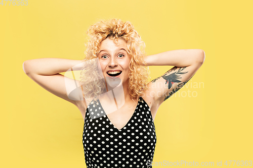 Image of Caucasian young woman\'s half-length portrait on yellow background