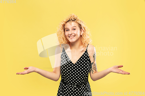 Image of Caucasian young woman\'s half-length portrait on yellow background