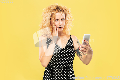 Image of Caucasian young woman\'s half-length portrait on yellow background