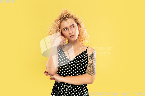 Image of Caucasian young woman\'s half-length portrait on yellow background