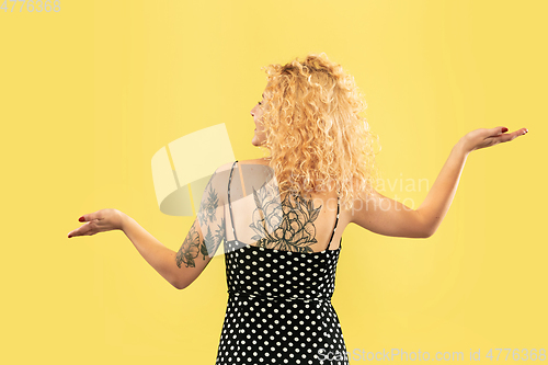 Image of Caucasian young woman\'s half-length portrait on yellow background