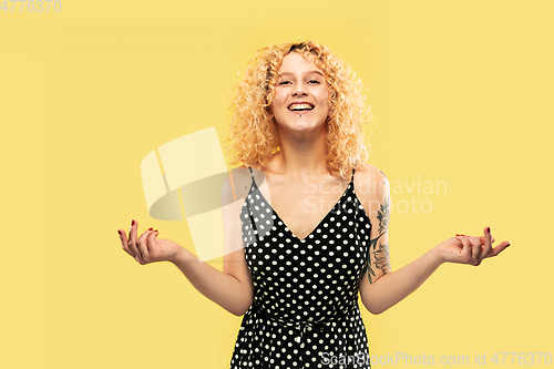 Image of Caucasian young woman\'s half-length portrait on yellow background