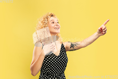 Image of Caucasian young woman\'s half-length portrait on yellow background