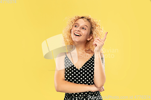 Image of Caucasian young woman\'s half-length portrait on yellow background