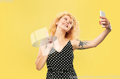 Image of Caucasian young woman\'s half-length portrait on yellow background