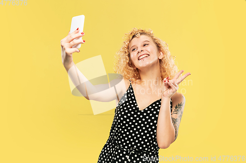 Image of Caucasian young woman\'s half-length portrait on yellow background