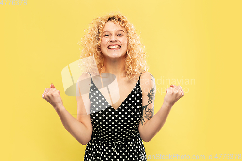 Image of Caucasian young woman\'s half-length portrait on yellow background