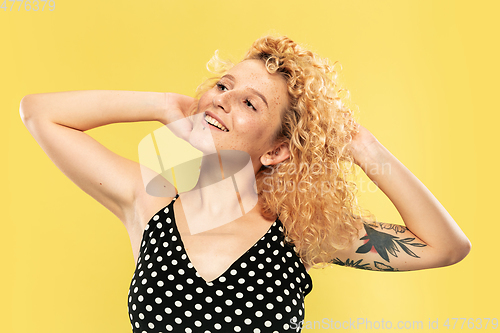 Image of Caucasian young woman\'s half-length portrait on yellow background