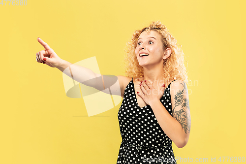 Image of Caucasian young woman\'s half-length portrait on yellow background