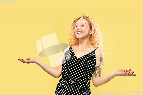 Image of Caucasian young woman\'s half-length portrait on yellow background
