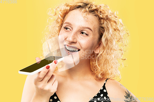 Image of Caucasian young woman\'s half-length portrait on yellow background