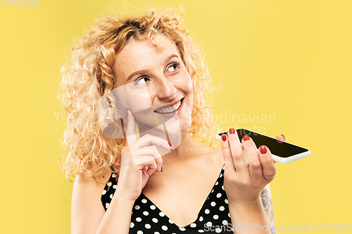 Image of Caucasian young woman\'s half-length portrait on yellow background