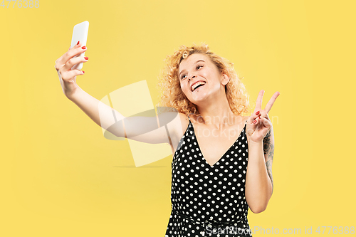 Image of Caucasian young woman\'s half-length portrait on yellow background