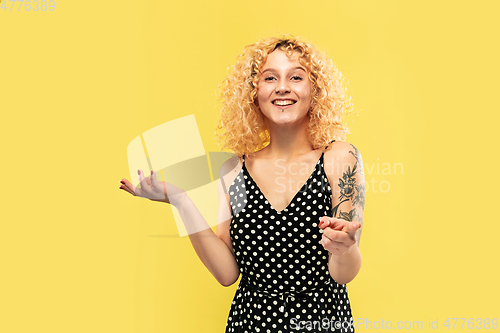 Image of Caucasian young woman\'s half-length portrait on yellow background