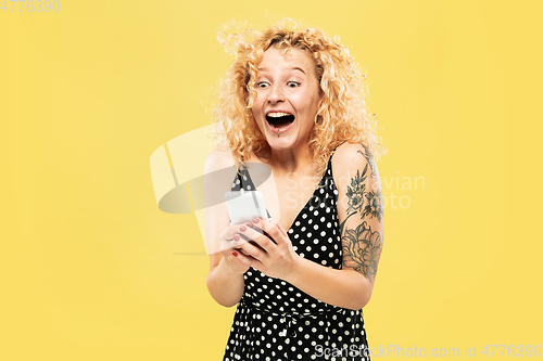 Image of Caucasian young woman\'s half-length portrait on yellow background