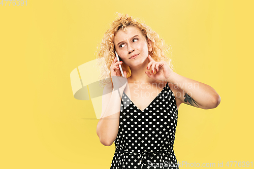 Image of Caucasian young woman\'s half-length portrait on yellow background