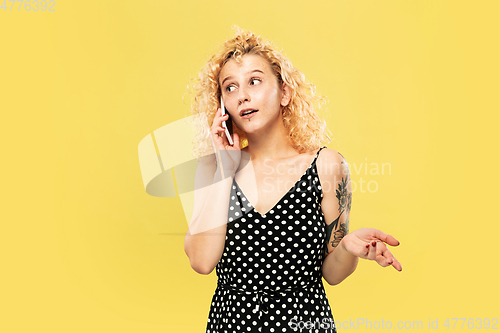 Image of Caucasian young woman\'s half-length portrait on yellow background