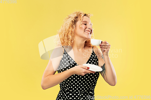 Image of Caucasian young woman\'s half-length portrait on yellow background