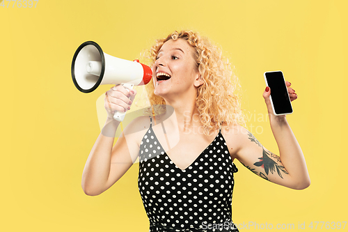 Image of Caucasian young woman\'s half-length portrait on yellow background