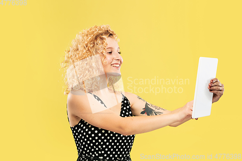 Image of Caucasian young woman\'s half-length portrait on yellow background