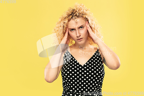 Image of Caucasian young woman\'s half-length portrait on yellow background