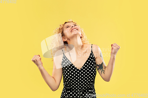 Image of Caucasian young woman\'s half-length portrait on yellow background
