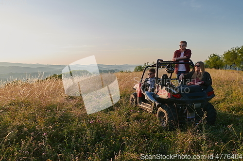 Image of group young happy people enjoying beautiful sunny day while driving a off road buggy car