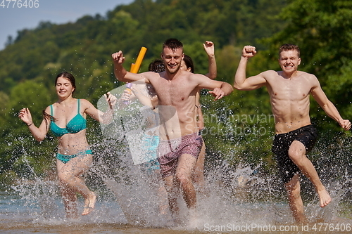 Image of group of happy friends having fun on river