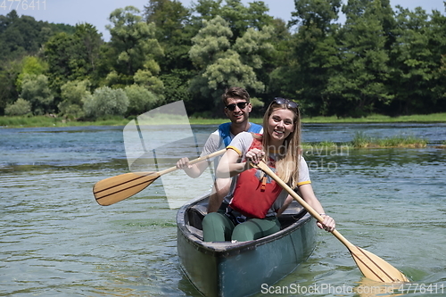 Image of friends are canoeing in a wild river